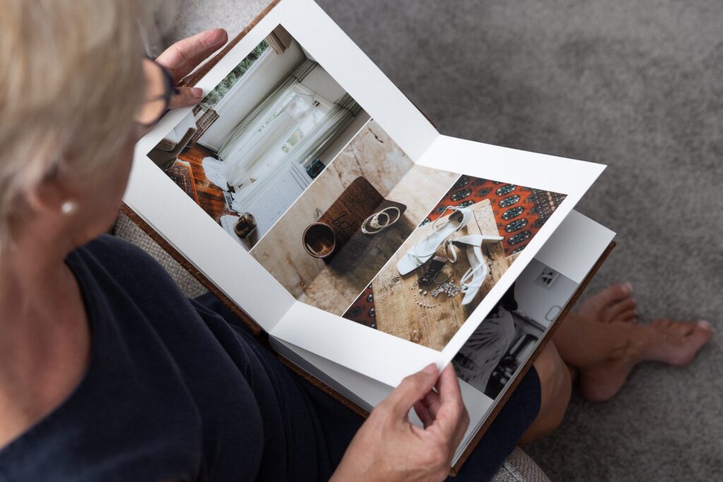 Over the shoulder photograph of a woman looking through a Wedding Album designed by a specialist photographer