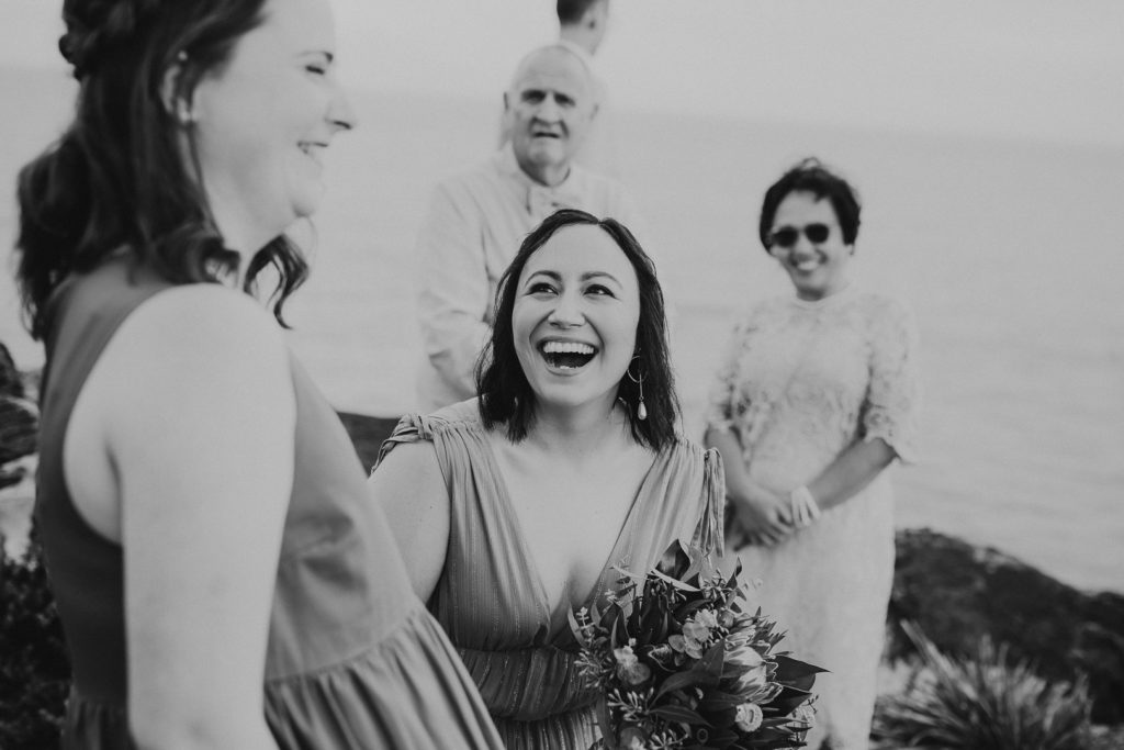Black and white image of a girl laughing out loud at a Central Coast Clifftop Elopement