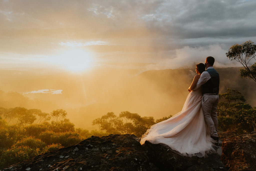 An epic sunset over Kangaroo Valley Bush Retreat with a married couple in the foreground