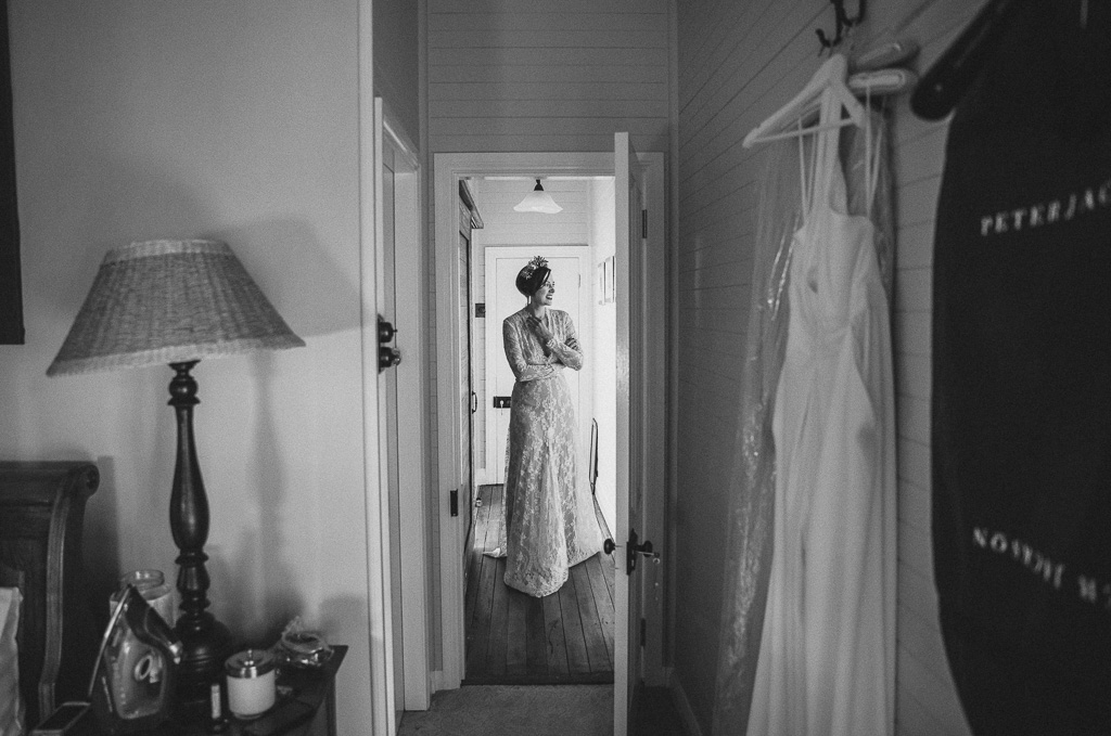 Bride stands in hallway looking anxious but beautiful, waiting for her wedding to begin
